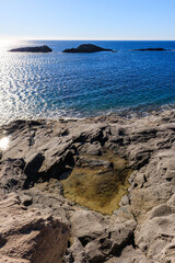 Fototapeta na wymiar unusual rock formations of the volcanic cliff on Cala Sapone beach, quartz-trachitic ignimbrites.