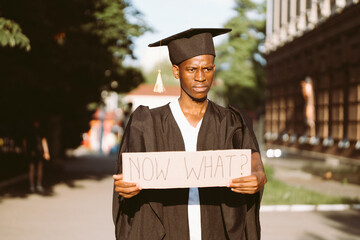 Portrait of poor afro american guy holding cardboard poster and lending hand on street. Looking for...