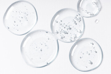 Drops and smears of cosmetics. Drops of liquid transparent gel with bubbles on a white background.