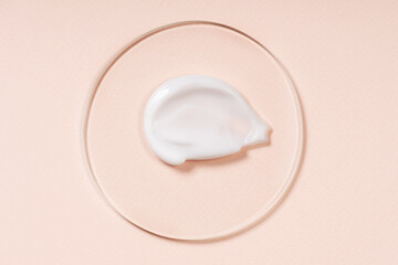 Cosmetic background, smears of cream on glass, texture of cream on a pastel beige background.