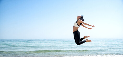 Fitness Girl jumping on the beach
