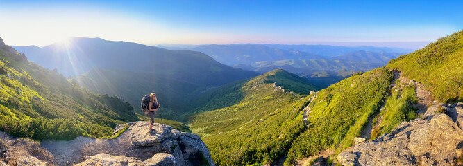 Young woman and her dog on mount Vuhaty Kamin. Panorama. Chornohora ridge, Carpathian mountains, Ukraine.
