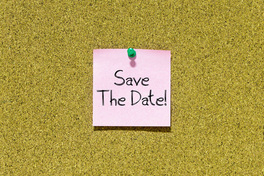 Save the date text on pink post-it paper pinned on bulletin cork board. This message can be used in business concept about save the date.