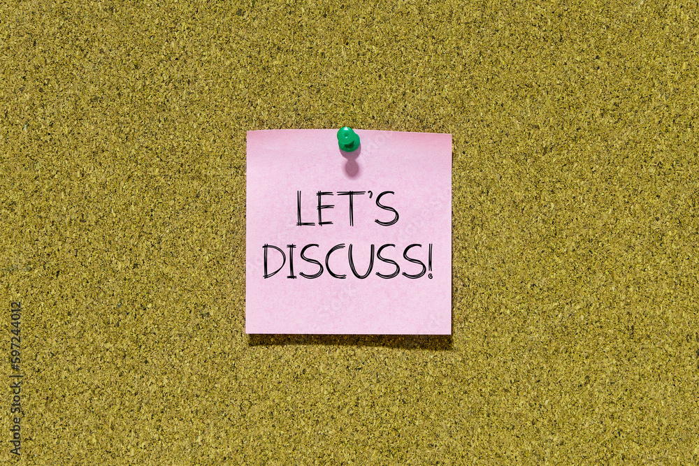 Poster let's discuss text on pink post-it paper pinned on bulletin cork board. this message can be used in 