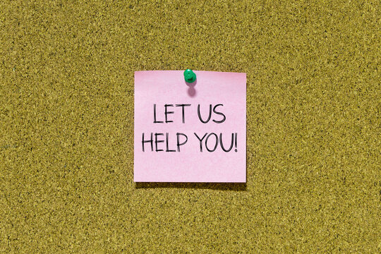 Let us help you text on pink post-it paper pinned on bulletin cork board. This message can be used in business concept about let us help you.