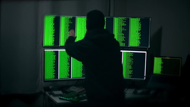 Unrecognizable Cyber Hacker Typing, Pointing and Nodding Head While Hacking Data on a Computer System. Shot with ARRI Alexa in ARRIRAW and exported QuickTime Apple ProRes 422 HQ.