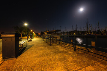 Night view of Balaton lake in Hungary, scenic landscape with yacht marine in moonlight, starry sky...