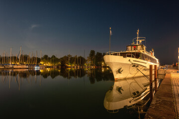 Night view of Balaton lake in Hungary, scenic landscape with yacht marine in moonlight, starry sky...