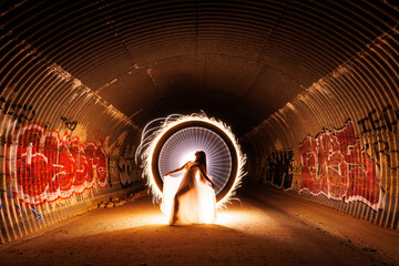 Sparkler Light Painting of a Beautiful Woman in a Storm Drain - 597247472