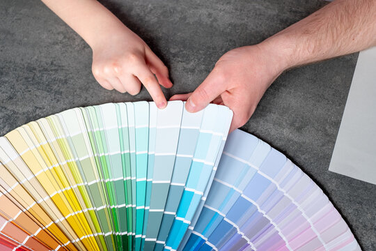 Close up family choosing samples the colors painting of the walls into apartment. Renovation of the house. top view