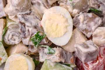 Delicious salad with boiled beef tongue, quail eggs, tomatoes and cucumber