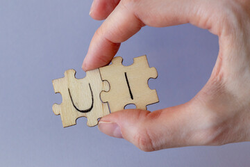 The acronym UI, which stands for User Interface. The letters written on the puzzles