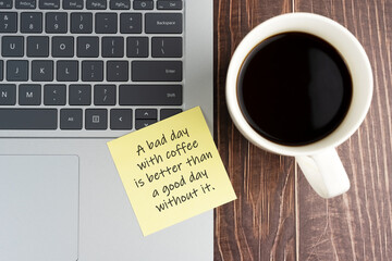 Laptop and sticky note of coffee mug with text - A bad day with coffee is better than a good day without it.