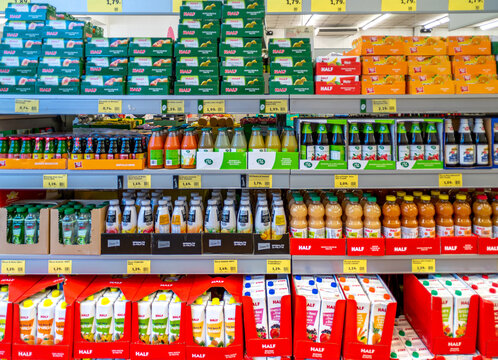 Italy - April 27, 2023: Bottled and canned fruit juices on shelf in Italian discount store