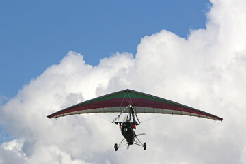 Fototapeta na wymiar Ultralight airplane flying in a cloudy sky 