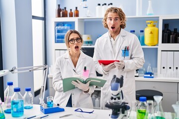 Two people working at scientist laboratory in shock face, looking skeptical and sarcastic,...