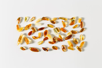 Natural gemstone amber stones with glare shadows, yellow orange colored on white background....