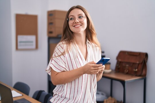 Young blonde woman business worker smiling confident using smartphone at office