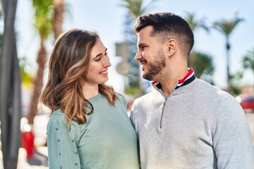 Obraz premium Man and woman smiling confident hugging each other standing at street