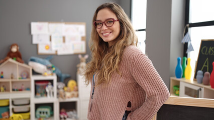 Young beautiful hispanic woman preschool teacher smiling confident standing at kindergarten
