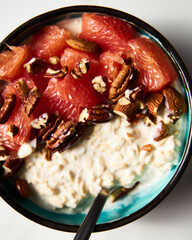 Overnight oats with milk and greek yogurt. healthy breakfast with nuts with grapefruit, honey and cinnamon. Top view