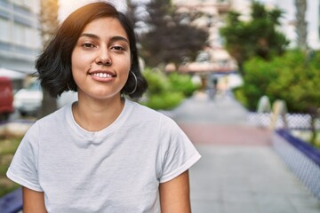 Young latin woman smiling confident standing at street