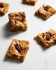 blondie cookies squares on white marble countertop background. White chocolate sweet and tasty, chewy cookie bars. 