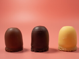 Chocolate covered marshmallow on a pink background.