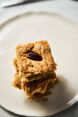 blondie cookies squares on white plate. Composition of sweet breakfast with coffee and blondie cookies.