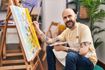 Young bald man artist smiling confident drawing at art studio