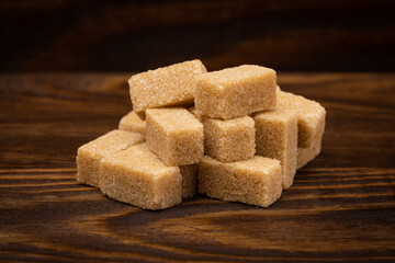 Brown sugar isolated on wooden background
