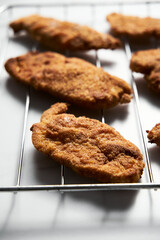 Close Up of Baked Chicken Schnitzel in breadcrumbs schnitzel on grid. 