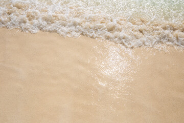 Fototapeta na wymiar A beautiful sandy beach with an incoming sea wave at a resort in Cancun, Mexico. Closeup. Space fot text