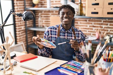 Fototapeta premium African american man artist smiling confident drawing on notebook at art studio