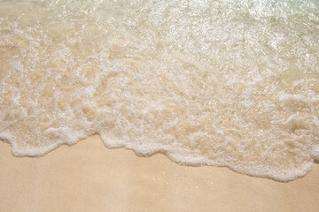 Fototapeta na wymiar A beautiful sandy beach with an incoming sea wave at a resort in Cancun, Mexico. Closeup. Space fot text