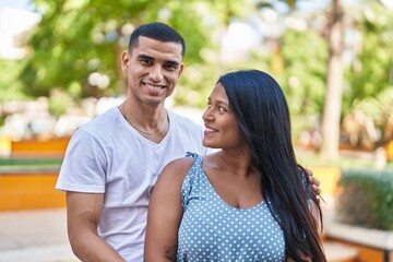 Obraz premium Man and woman couple smiling confident standing together at park