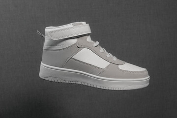 One White, high winter sneaker made of leather. On a gray background. isolated