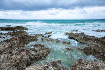 Tropical storm in the Atlantic Ocean. Beautiful rocky shore with rolling waves. Hurricane in Caribbean Sea, Gulf of Mexico, Cancun.