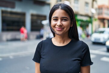 Young latin woman smiling confident standing at street