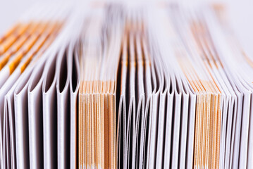 Edge of a file of paper advertising brochures with a blurred background