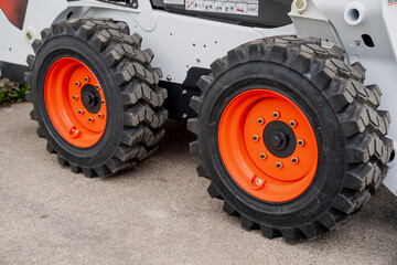 Construction loader big fresh new wheels with warning orange disks. Construction vehicle wheels