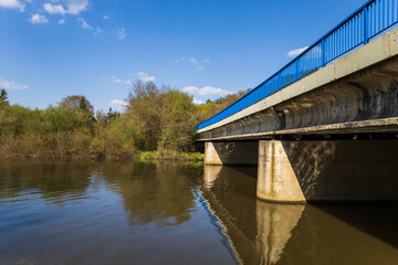 Concrete bridge over the river Svratka. There is a blue railing on the bridge.