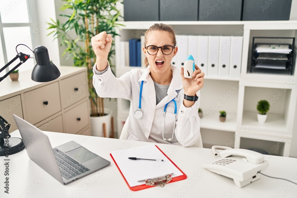 Wall mural young doctor woman wearing uniform and stethoscope annoyed and frustrated shouting with anger, yelli