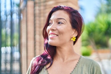 Young beautiful hispanic woman smiling confident looking to the side at street