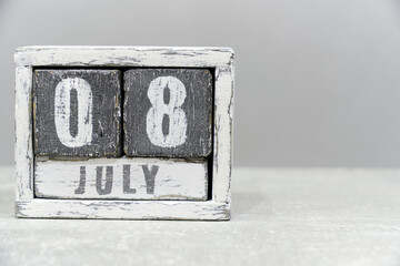 Calendar for July 08, made of wooden cubes, on gray background.With an empty space for your text.