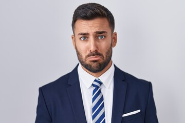 Handsome hispanic man wearing suit and tie depressed and worry for distress, crying angry and afraid. sad expression.