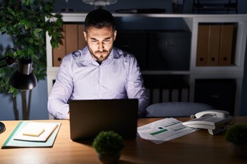 Young hispanic man business worker working overtime at office