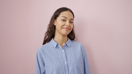Fototapeta premium Young beautiful hispanic woman smiling confident over isolated pink background