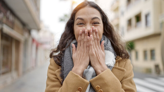 Young beautiful hispanic woman standing with surprise expression at street