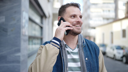 Young caucasian man smiling speaking on the phone at street